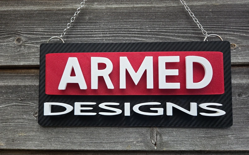 ArmMed Designs 3D printed hanging sign in red, white and black.