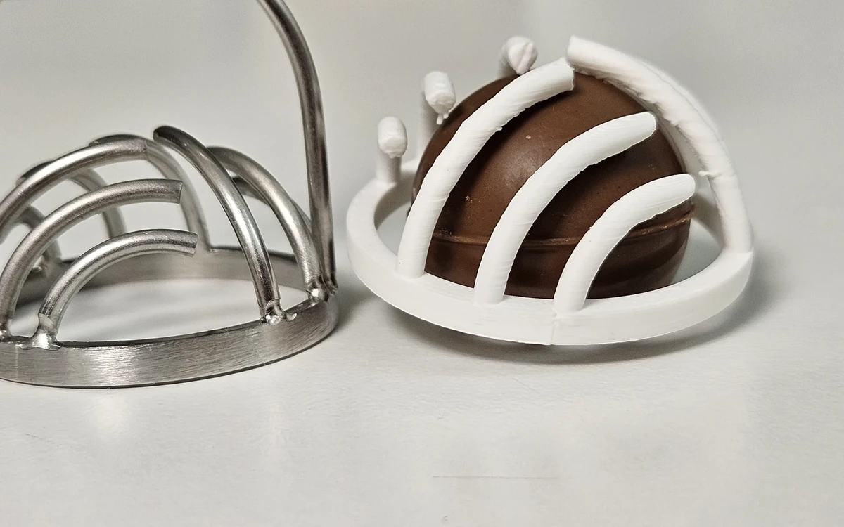 Original metal chocolate decorating tool and a white printed prototype fitted over a chocolate sample.